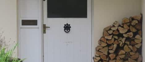 Eine weiße Tür mit einem schwarzen Fenster und einem Schild mit der Aufschrift "Forder Cottage".