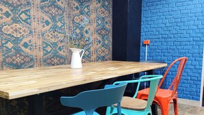 A wooden table with four chairs, a white pitcher, and a patterned wall. - VIKI Kazimierz (Kraków)