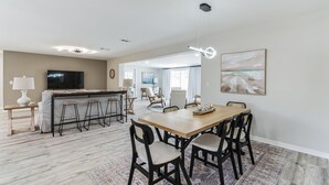 A modern living room with a dining area, a kitchen, and a TV. - Coastal Comfort Getaway in the Heart of SRQ (Sarasota)
