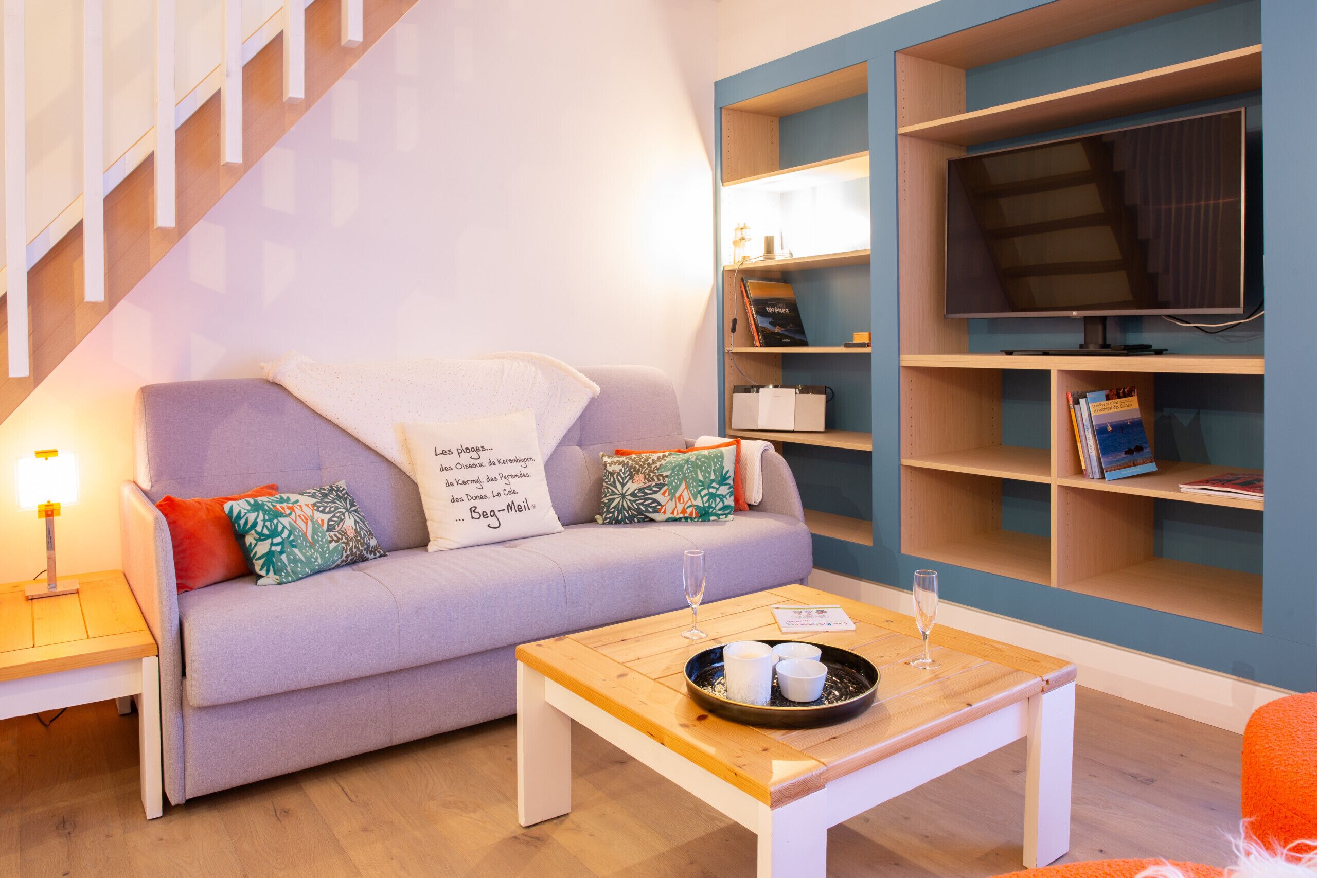 A modern living room with a sofa, coffee table, and bookshelves.