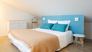 Un dormitorio con cama, mesita de noche, perchero y armario.