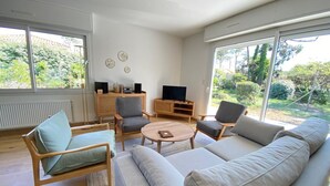 En moderne stue med sofa, stole, sofabord og TV-møbel.