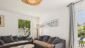 Un soggiorno moderno con divano, tavolino, lampada e un quadro appeso al muro.