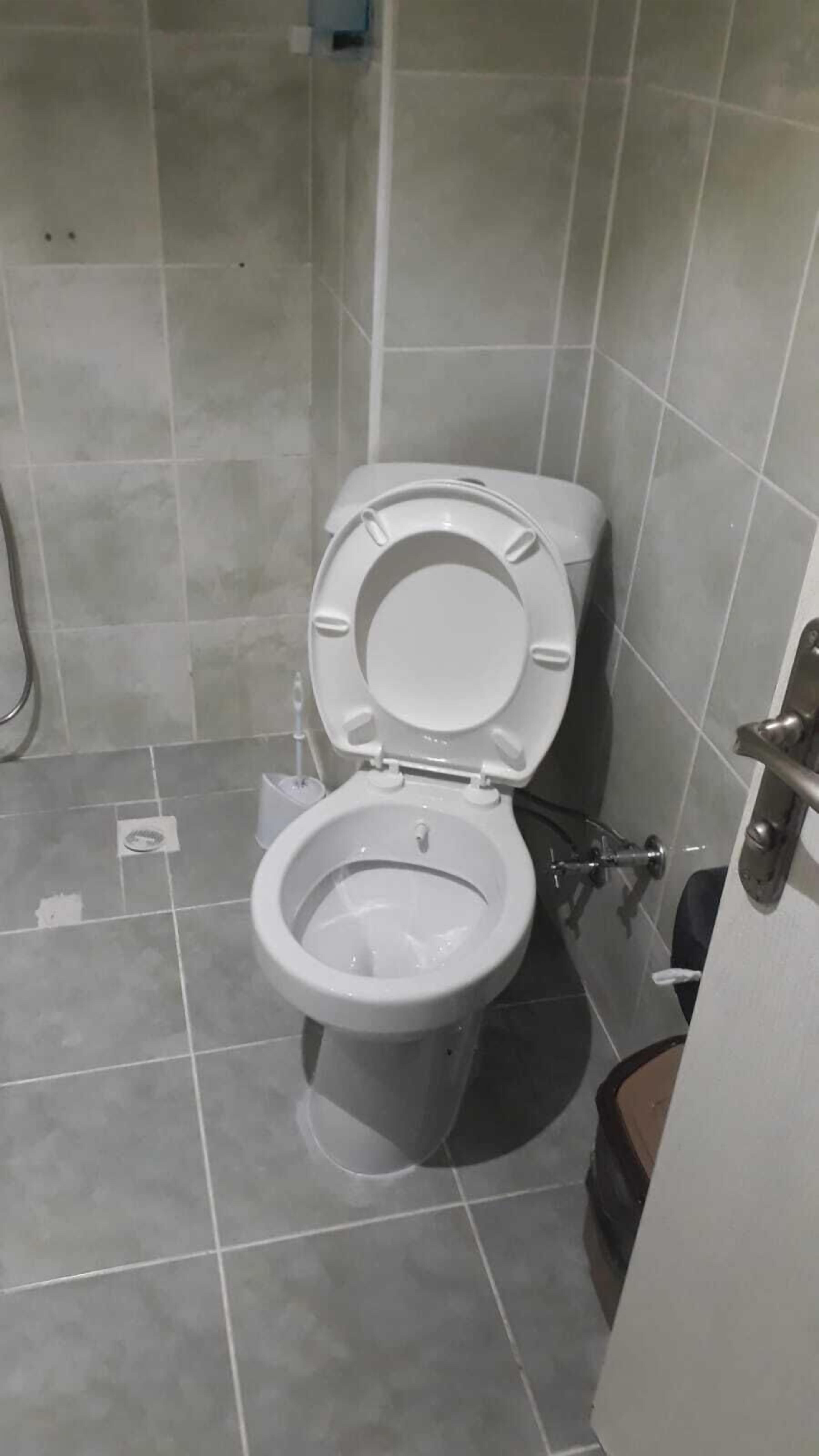 A standard bathroom with a toilet, a bidet, and a shower area.