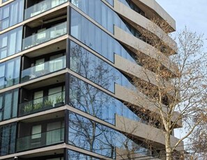 Un edificio moderno de varios pisos con balcones y ventanas amplias.