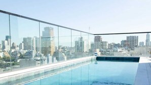Une piscine sur le toit offrant une vue panoramique sur la ville.