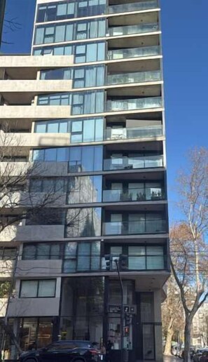 Un edificio de varios pisos con un diseño arquitectónico moderno, que presenta grandes ventanales en cada planta.