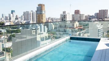 Una piscina en la azotea con vista al horizonte urbano.