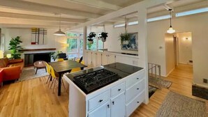 A spacious kitchen with a central island, white cabinetry, and hanging plants. - Best Vacation Home in Arlington, 4 bedrooms 3 full bath, 8 beds, 12 guests (Arlington)
