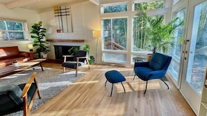 A spacious living room with a fireplace, large windows, and a variety of seating options. - Best Vacation Home in Arlington, 4 bedrooms 3 full bath, 8 beds, 12 guests (Arlington)