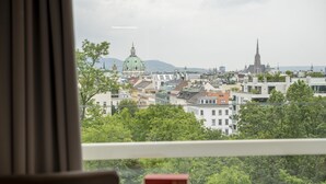 Vista desde una ventana sobre un paisaje urbano con edificios y zonas verdes.