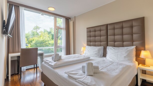 Una habitación de hotel con una cama grande, un escritorio y una silla.