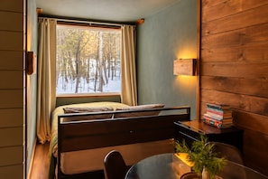 Cozy woodland bedroom with warm wood tones and serene snowy views - Modern Forest Cabin | Hot Tub + Sauna + Stream (Saugerties)