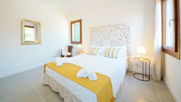A hotel room with a large bed, a chair, a nightstand, and a window. - DolceVita Apartments N. 491 (Venice)