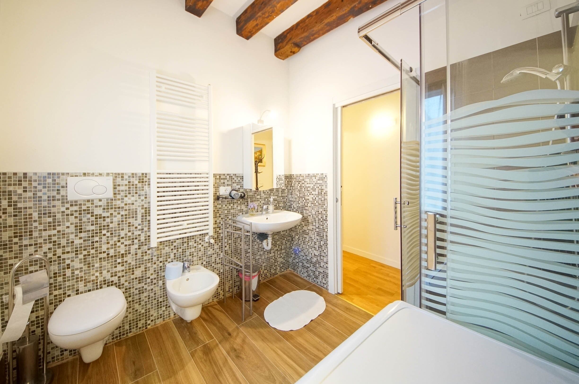 Un baño con dos inodoros, un lavabo y una zona de ducha.