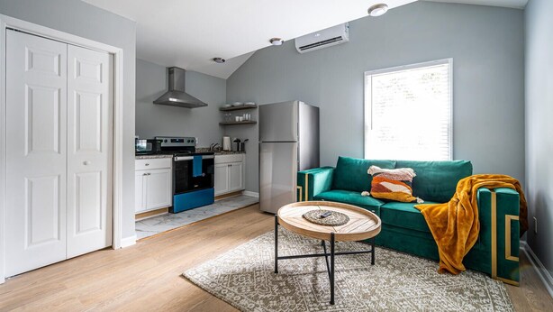 Een knus woongedeelte met een kitchenette, een bank en een salontafel.