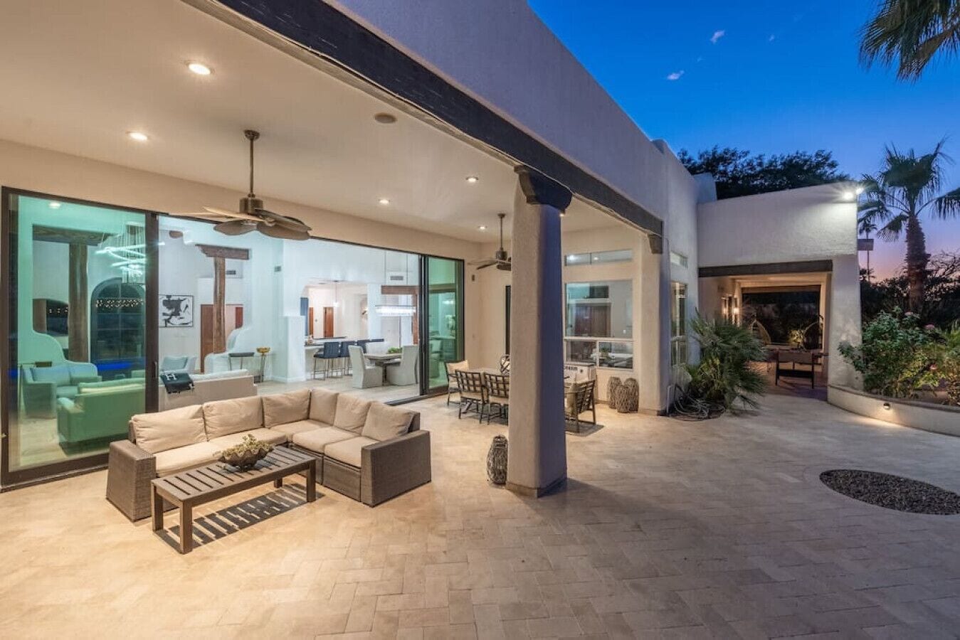 A modern outdoor living area with a sofa, coffee table, and dining set.