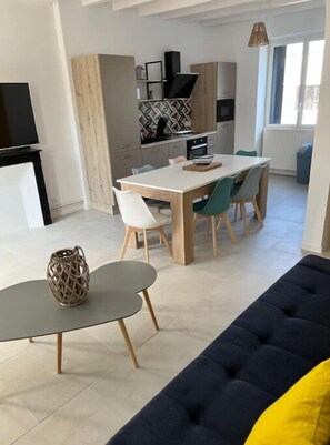 Un espace de vie moderne comprenant un coin repas, un canapé et un téléviseur.