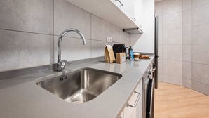 Una cocina moderna con un lavamanos de acero inoxidable, una cafetera y un tostador.