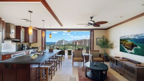 Una cocina amplia con una isla grande, comedor con sillas y vistas al océano.