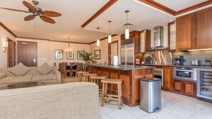 Una cocina moderna con armarios de madera, electrodomésticos de acero inoxidable y una zona de bar.