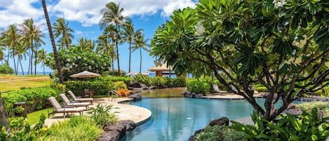 A garden pool that opens toward the palms and the ocean past them.