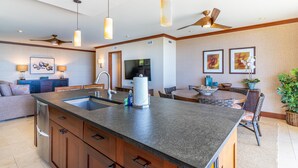 A modern kitchen with a central island, built-in cabinetry, and a dining area with a round table and chairs.