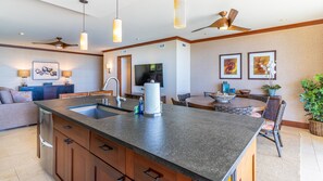 A modern kitchen with a central island, built-in cabinetry, and a dining area with a round table and chairs.