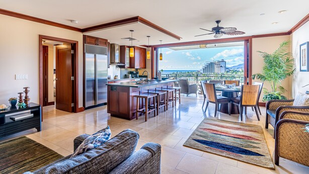 A spacious living area with a kitchen, dining area, and a balcony with a view.