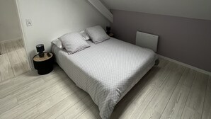 A bedroom with a skylight, a bed, a bedside table, and a nightstand. - Charmante Maison en Brenne (Vendœuvres)