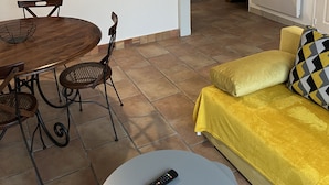 A compact living space with a dining area, kitchenette, and a sofa. - Charmante Maison en Brenne (Vendœuvres)