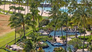 A resort with a pool area, palm trees, and a beach.