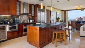 Una cocina moderna con armarios de madera, electrodomésticos de acero inoxidable y una isla grande con taburetes.