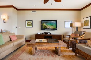 Una sala de estar con sofá, mesa de centro, televisor y sillón.