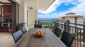 A balcony with a dining table, chairs, and a fruit bowl. - Ko Olina Beach Villas O1121: Luxurious Villa w/Golf Course & Ocean Views (Kapolei)