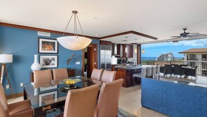A modern dining area with a glass table, leather chairs, and a view of the ocean. - Ko Olina Beach Villas O1121: Luxurious Villa w/Golf Course & Ocean Views (Kapolei)