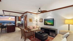 A modern living room with a sofa, ottoman, and dining area.