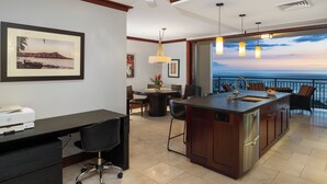 A modern kitchen with a large island, dining area, and a view of the ocean.