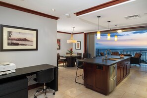 A modern kitchen with a large island, dining area, and a view of the ocean.