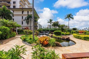 Een resort met een aangelegde tuin, een kleine waterval en een zwembadgedeelte.