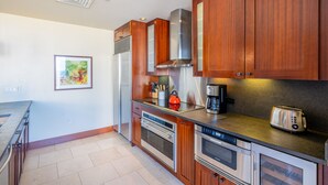 Una cocina moderna con armarios de madera, electrodomésticos de acero inoxidable y encimera negra.