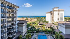 Un hotel de varios pisos, con zona de piscina y vistas a la playa y al océano.