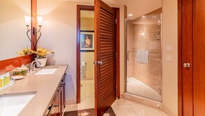 Un baño moderno con tocador, ducha y puerta de madera.