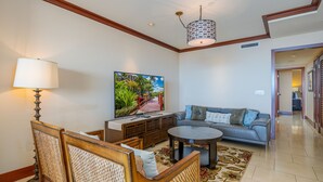 A living room with a sofa, a coffee table, a TV, and a lamp.