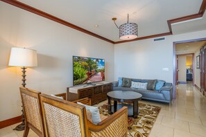 A living room with a sofa, a coffee table, a TV, and a lamp.