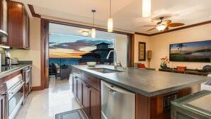 Una cucina moderna con una grande isola, elettrodomestici in acciaio inossidabile e vista sul paesaggio costiero.