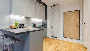 Une cuisine moderne avec un îlot central, des meubles gris et un plancher en bois.