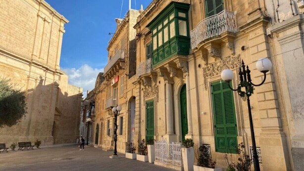 A historic street with traditional architecture, including ornate balconies and green shutters. - Lovely 1BR Studio home in Quiet Town of Zejtun (Iż-Żejtun)