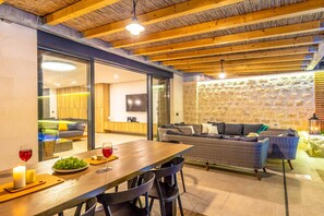 Enjoy meals in the dining area with a wooden table, candle, and fresh fruit.