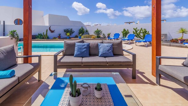Eine Dachterrasse mit Pool, Sitzgelegenheiten im Freien und Kakteen.